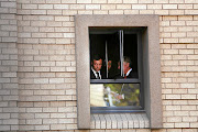 Oscar Pistorius peeks out a window during a break in his murder trial in the Pretoria High Court in 2014. 