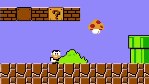 A gif showing a pixelated man running  through a Mario level and growing when he touches a mushroom. 