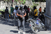 A demonstrator holds a gun after breaking into prime minister Ariel Henry's official residence in Port-au-Prince, Haiti during a protest on January 26 2023 about the recent killings of police officers by armed gangs.