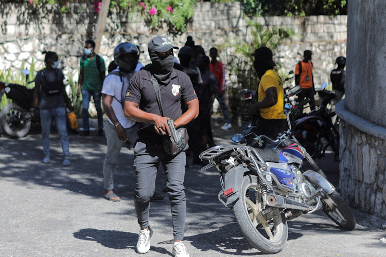 A demonstrator holds a gun after breaking into prime minister Ariel Henry's official residence in Port-au-Prince, Haiti during a protest on January 26 2023 about the recent killings of police officers by armed gangs.