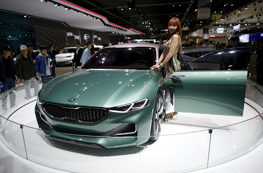 A model poses next to a Kia Motor's concept car Novo at the Seoul Motor Show 2015 in Goyang in this April 3, 2015 file photo. Kia Motors plans to launch its first sports sedan next year, people familiar with the matter told Reuters, seeking to burnish a sporty, younger image as larger sibling Hyundai Motor builds up its premium offerings. REUTERS/Kim Hong-Ji/Files