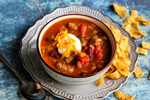 Steak Chili with sour cream and cheddar cheese on top.