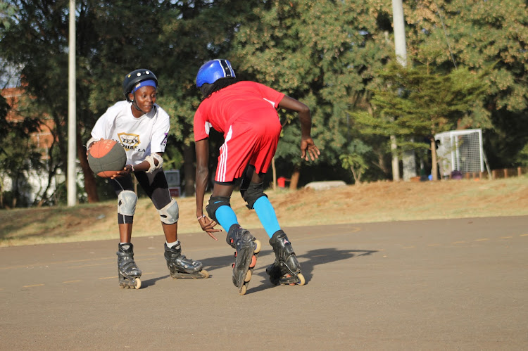 Archibella's Mary Wambui (white) skates past Reccebella's George Mbutu (red) during training at the University of Nairobi graduation Square on April 11.