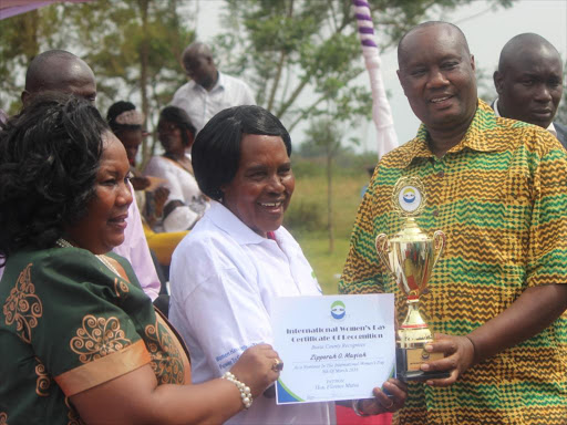 FOR YOUR GOOD WORK: Governor Sospeter Ojaamong awards Zipporah Mayiah for her service to the people in Busia town yesterday.