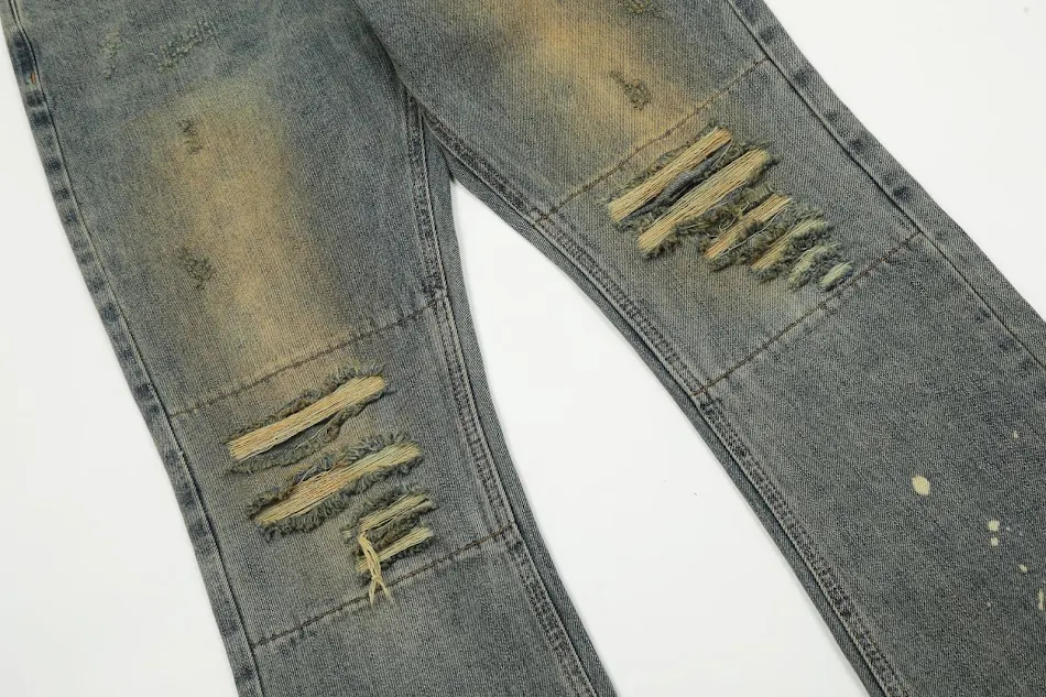 Macacão com pernas largas, corte reto lavado e estampado com respingos de tinta, modelo flare. Conforto e estilo em uma peça única, ideal para diversas ocasiões.