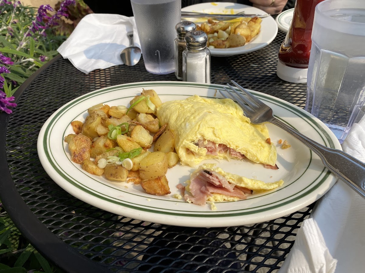 Beakfast at a sidewalk table. Ham & cheese omelette with potatoes.