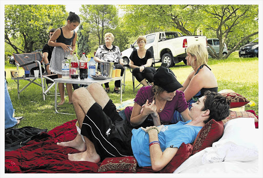 Thomas Ferreira, his girlfriend, Chanel Kloppers, and family members enjoy a picnic in the garden of the Riverfield Lodge rehabilitation unit.