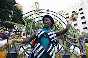 Zandile Dumile of the Greenmarket Hub leads dancers during the Cape Town Carnival. 