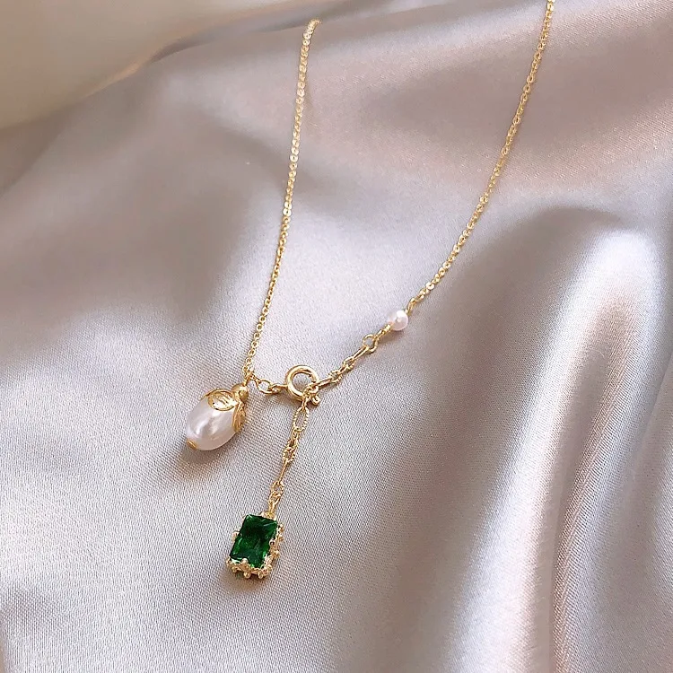 Collier pendentif simple émeraude et perle, élégant blanc. Rehaussez votre style avec ce bijou intemporel, parfait pour une touche de raffinement.
