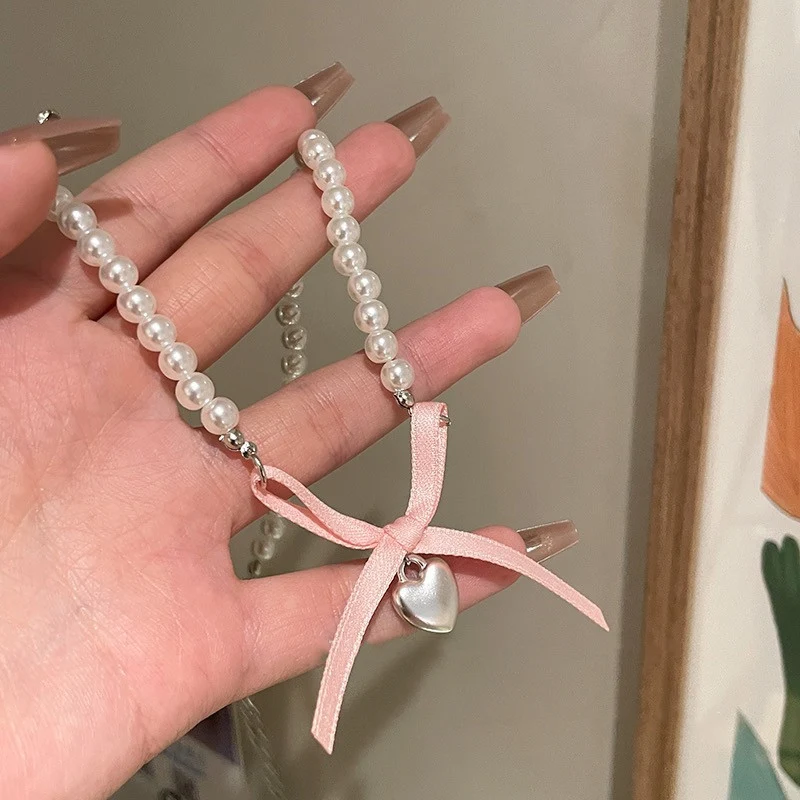 Collier perlé court femme avec nœud coloré et fleurs, un bijou élégant et féminin pour sublimer votre tenue et apporter une touche de raffinement.