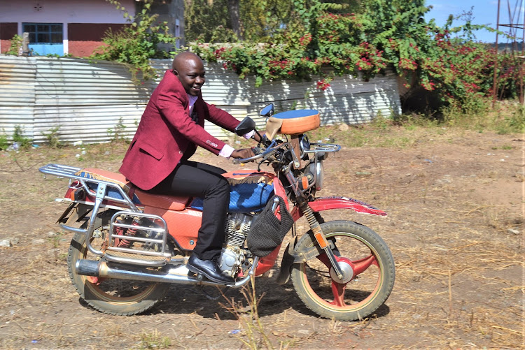 Kitui county chief officer for transport and boda boda Peter Musya who is a former boda boda rider, tries his hand on a motorbike after the meeting with boda boda leaders from Kitui West on Monday.