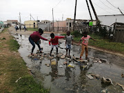 Children cross a stream of sewage in Soweto-on-Sea, Port Elizabeth. 