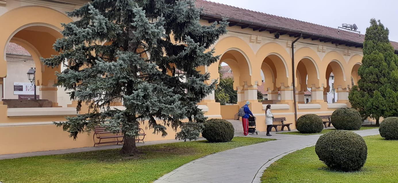 Alba Iulia citadel with a couple with stroller near a bench.