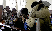 ACCUSED Five suspects try to hide their faces at their  court appearance in Estcourt  Picture: Khaya Ngwenya