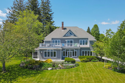 Gray house with balcony and green garden in this luxury house for sale in Rockport ($1,650,000)