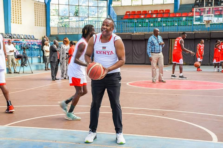 ICT CS Eliud Owalo, a former basketball player, displays his skills after donating uniforms to Kenya men's national basketball team, the Morans on February 14.