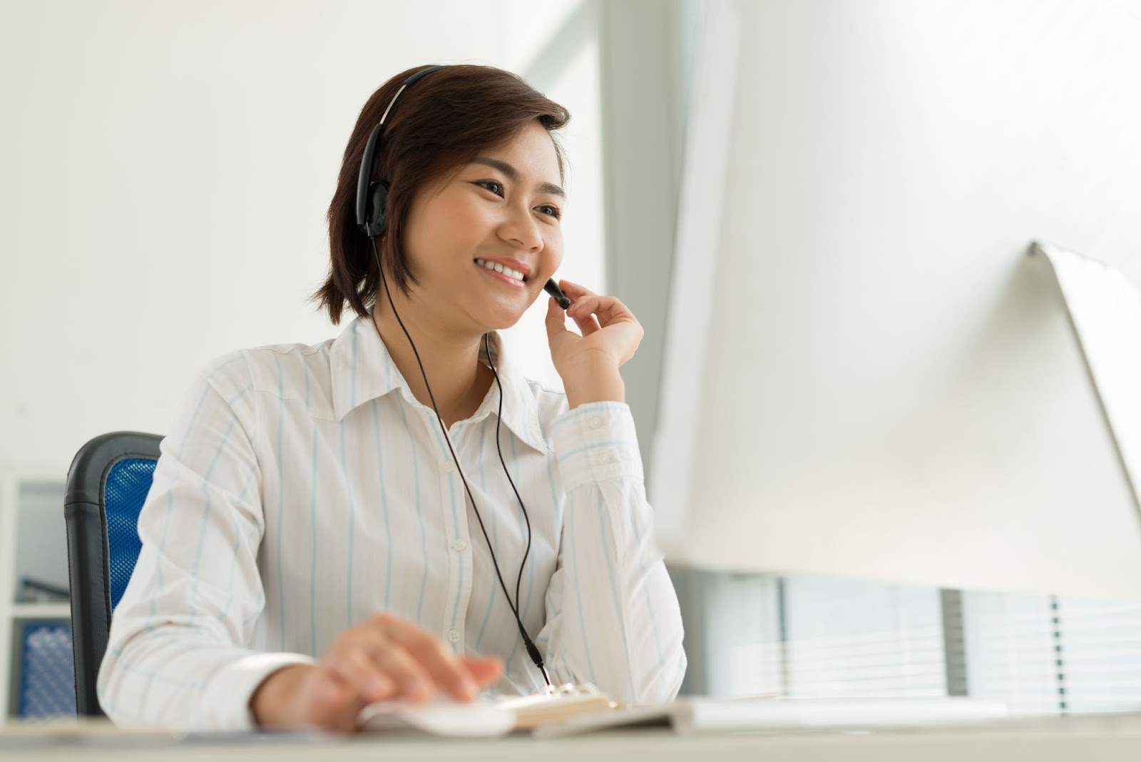 a woman wearing headphones and talking on a headset
