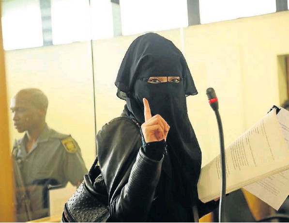 Fatima Patel, the common-law wife of Aslam Del Vecchio, raises a single index finger in the Verulam Magistrate’s Court, where she appeared on terror-related charges