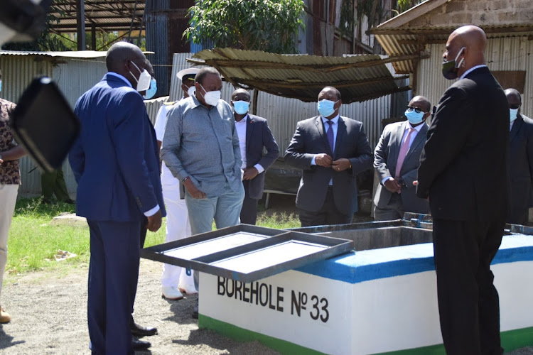 President Uhuru Kenyatta and, among others, Nairobi Metropolitan Services director general Mohamed Badi at a Kibera water borehole on June 30.