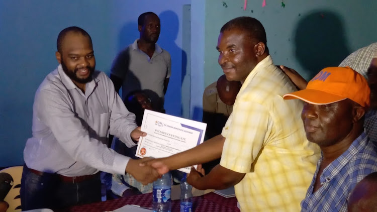 County Returning officer Solomon Wachira Njeru issue a certificate to Ali Hassan Mwakulonda at Msambweni main tallying center in Kwale on Monday, March 4, 2022.