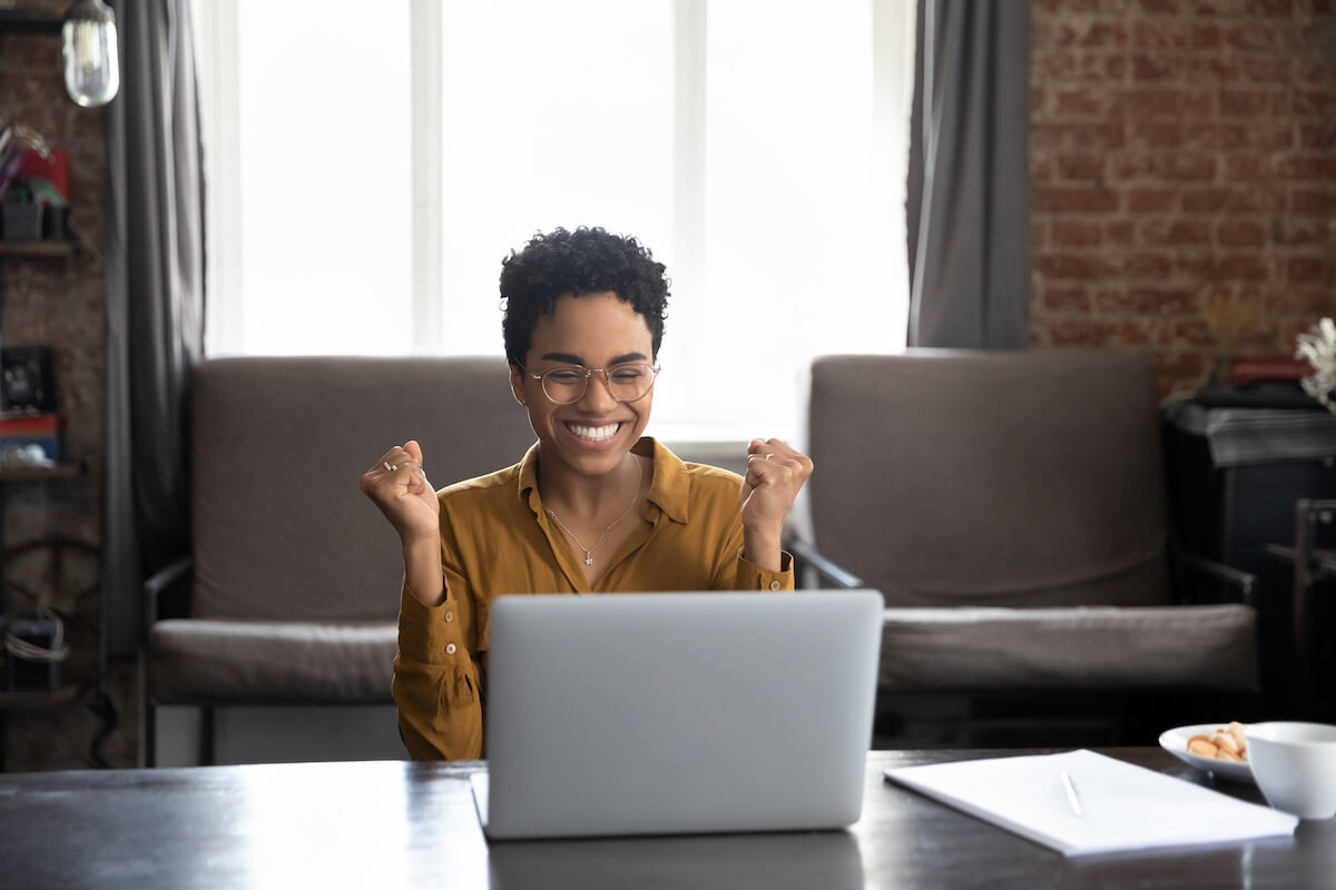 Applicant tracking system: excited entrepreneur looking at a laptop