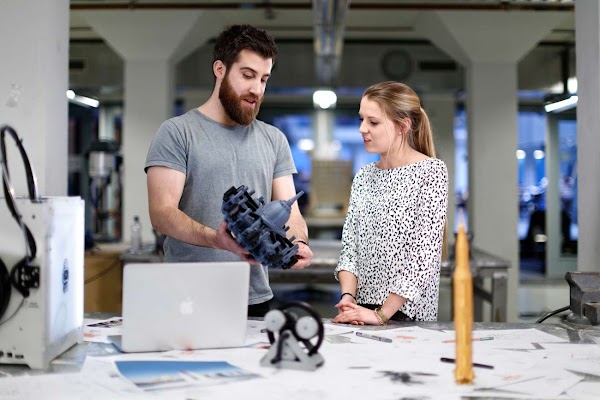 Male student showing another student 3D printed parts