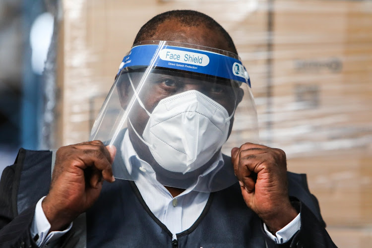 President Cyril Ramaphosa tries on Personal Protective Equipment donated to South Africa's healthcare workers on 30 April 2020, at the Takealot warehouse in Kempton Park.