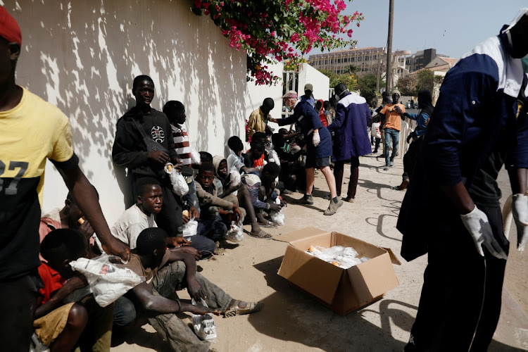 Children receive their meal from members of the Village Pilote association during a food distribution to street children amid an outbreak of the Covid-19 coronavirus, in Dakar, Senegal April 1, 2020.