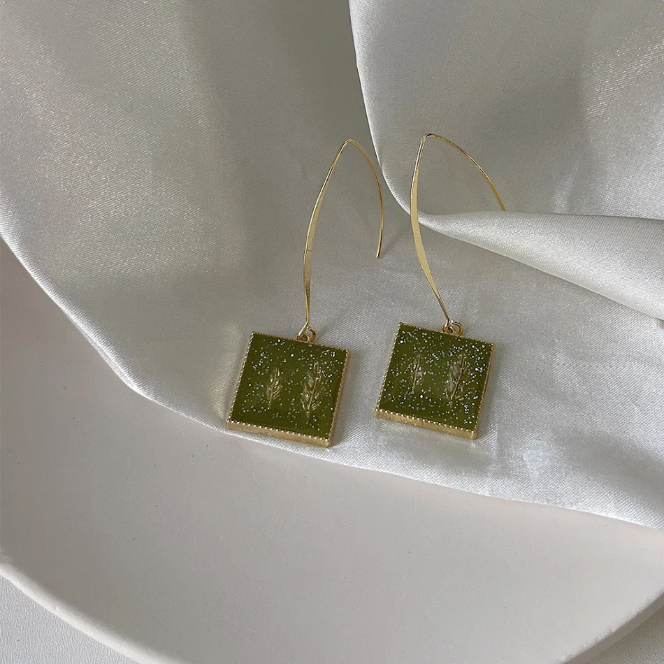 Damenmode Ohrringe mit einfachem Design, Silberstift und avocado-grünen Steinen. Stilvolle Ohrstecker, ideal für den täglichen Gebrauch.