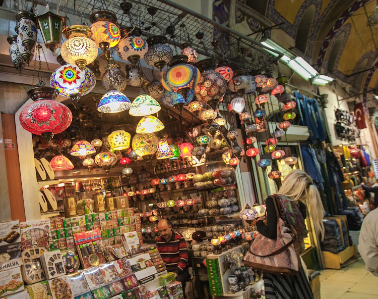 A women admires the assortment of colorful lamps at a shop in the Grand Bazaar in Istanbul.  