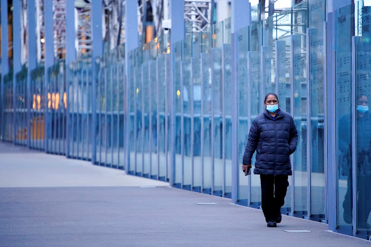 A woman wearing a protective face mask walks along a deserted city bridge during a lockdown in Melbourne in July 2021. Picture: REUTERS/SANDRA SANDERS