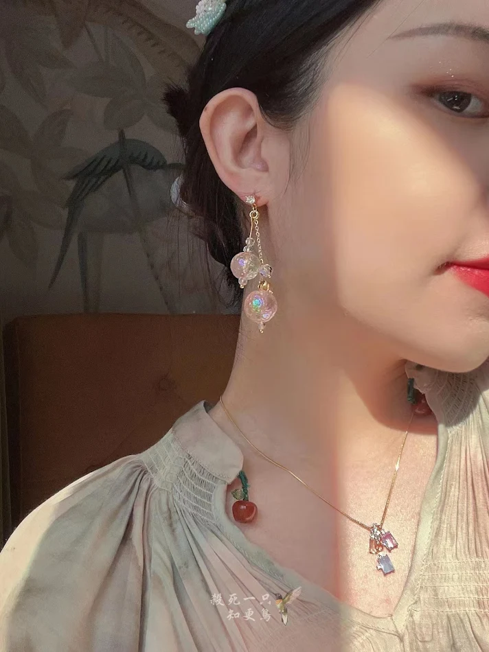 Boucles d'oreilles girly roses pêche en forme de boule de verre colorée et féerique, un accessoire mignon et scintillant pour illuminer votre visage