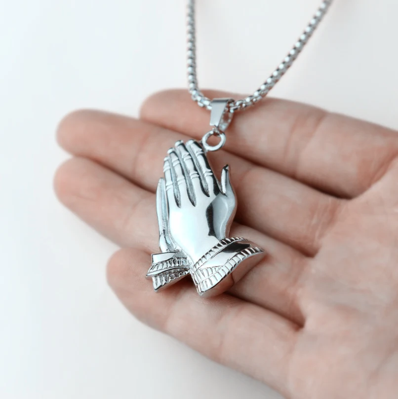 Colar com pingente de oração em aço inoxidável com bergamota dourada para homens. Mãos unidas, fé e estilo em uma joia.