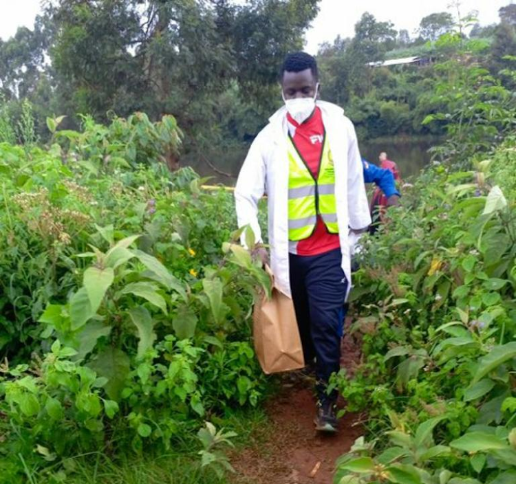 A detective carries a paper bag containing a human head believed to be that of slain university student Rita Waeni from a dam in Kiambaa, Kiambu County, January 21, 2024.