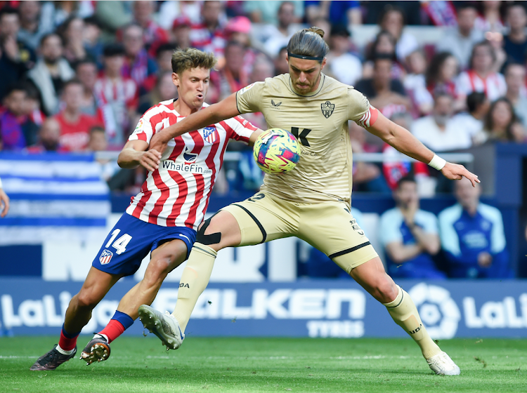 Almeria's Srdjan Babic (R) vies with Atletico Madrid's Marcos Llorente during a Spanish La Liga match on April 16