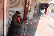 Security guard Gudda Ngubane sits with a sjambok in the Johannesburg CBD.  