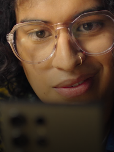 An Android user smirks while typing a message on their phone.