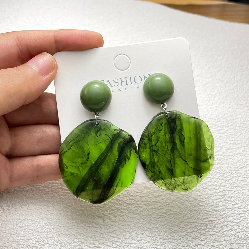 Boucles d'oreilles rondes en résine vert foncé fumé, un accessoire unique pour femmes. Parfaites pour compléter toutes vos tenues.