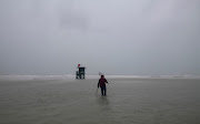 A person uses a metal detector on the beach engulfed by water before the arrival of Tropical Storm Eta in Siesta Key, Florida, US November 11, 2020. 