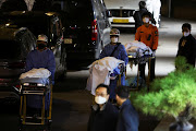 People move bodies to be transported from hospital, after a stampede during a Halloween festival in Seoul, South Korea, October 30, 2022. 