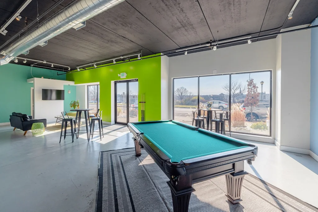 Resident lounge with billiards table, seating areas, and a TV