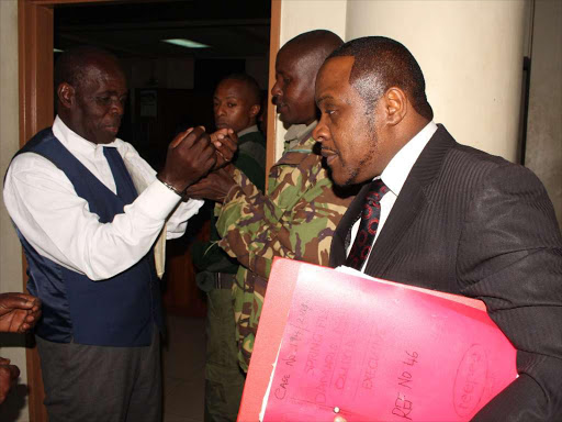 TeleEvangelist Gilbert Deya handcuffed by a Prison officer at a Milimani law court on Monday,October 2,2017 as his lawyer John Swaka (right) looks on when he appeared for the mention of his child trafficking case.He is facing five counts of stealing children PHOTO/COLLINS KWEYU