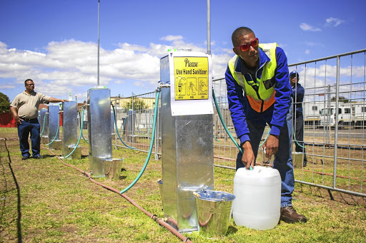 Brandon Herringer, a City of Cape Town plumber, demonstrates what a water collection point would have looked like if Day Zero had arrived.