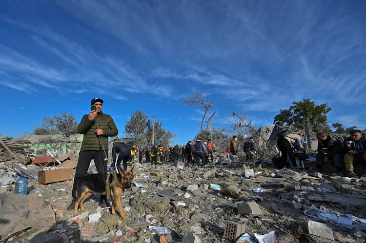 Local residents are seen at a site of a residential area heavily damaged by a Russian missile strike, amid Russia's attack on Ukraine, in Zaporizhzhia, Ukraine October 9, 2022.