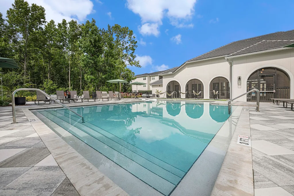 Community swimming pool with clubhouse in background