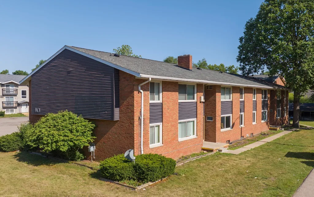 One of Pacific Apartments's buildings with a brick exterior and landscaping