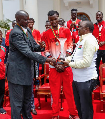 Bush Wamukota (C) and KBF chairman Paul Otula (L) presents the trophy to President Uhuru Kenyatta.