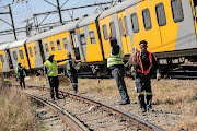 Metrorail workers work on the scene where two trains collided in Selby, near the Booysens train station, south of Johannesburg, on September 4. 