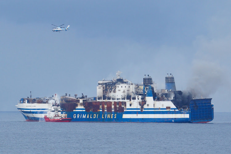 A Greek Navy helicopter flies over the burning Italian-flagged Euroferry Olympia, which sailed from Greece to Italy early on Friday and caught fire, off the coast of the island of Corfu, Greece, February 20, 2022.