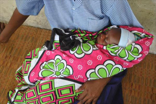 A 16-year-old girl breastfeeds her three-month-old baby. Ten girls are pregnant at the school.